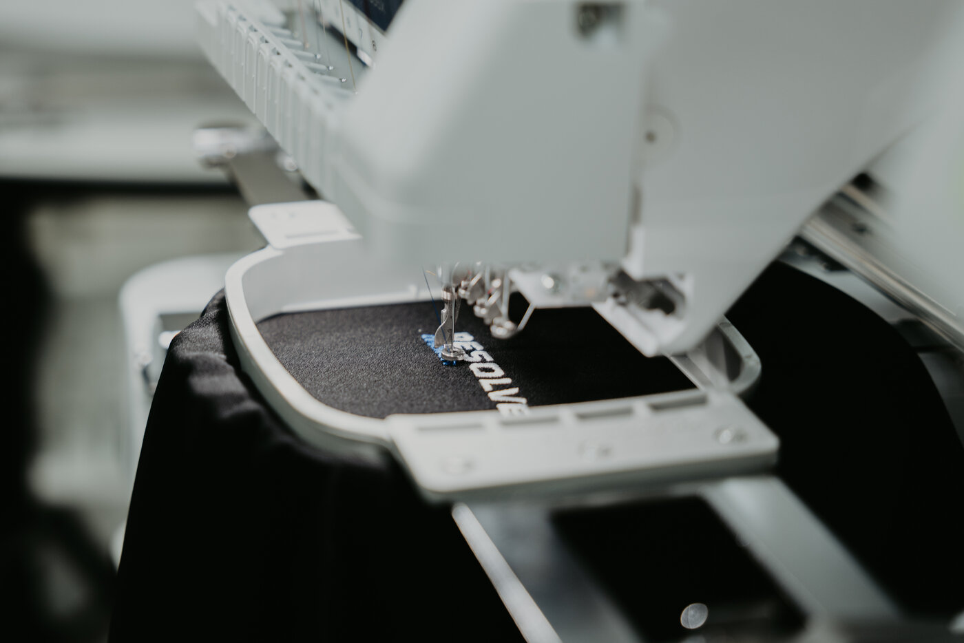 Embroidery machine stitching a logo in-house